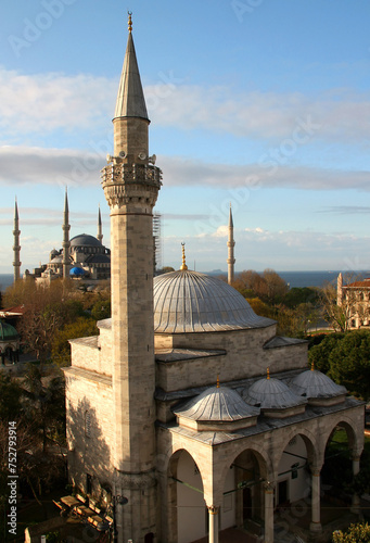 Photo of the Firuzaga mosque, part of the Hippodrome Square with the Obelisk and German Fountain and the Blue Mosque in the background in the historic district of Sultanahmet, Istanbul, Turkey photo