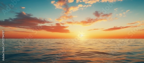 Vibrant Sunset over the Horizon Casting Warm Glows and Serene Reflections on Calm Waters © Ilgun