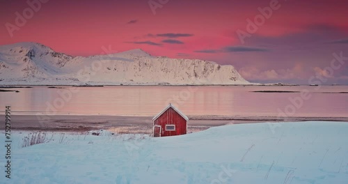 Color sunset winter landscape of nordic red house on the beach coast and mountain rodge of Lofoten islands, Norway photo