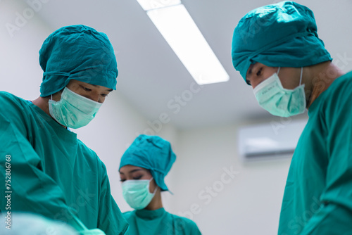 Focused surgeons performing surgery in operating room. Group of surgeons doing surgery in hospital operating theater.