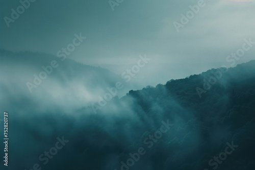 A serene scene of misty  fog-covered mountains in cool blue hues.