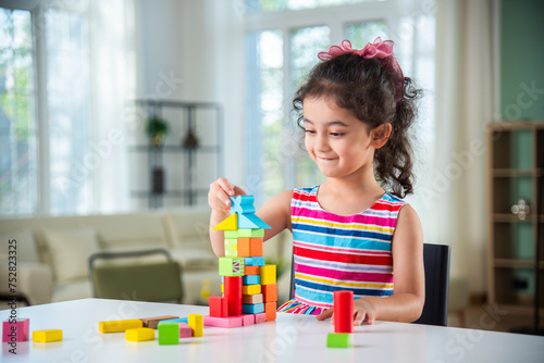 Indian asian child preschooler girl playing wooden toys at home or kindergarten