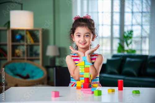 Indian asian child preschooler girl playing wooden toys at home or kindergarten