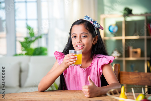 A beautiful Indian girl drinking fresh juice at home