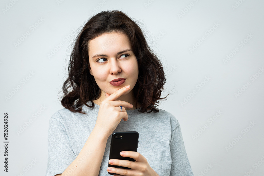 Beautiful young girl with phone looking aside Beautiful young girl with phone looking aside