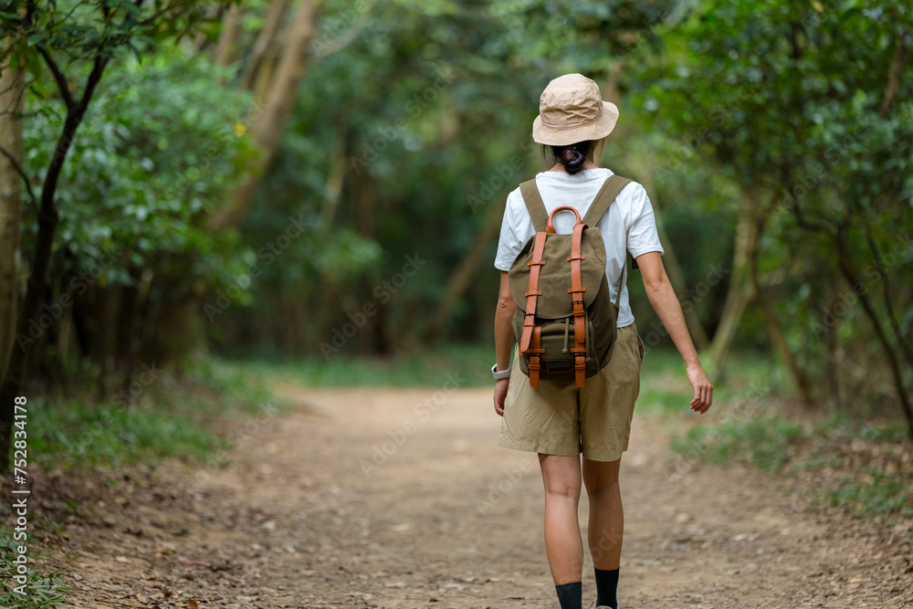 Woman walk along the hiking trail in the forest