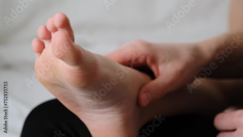 The mother is tickling the legs of her child. Mommy plays with kid. Healthy lifestyle. Barefoot close-up. Tactile contact and communication mom with her son. Gentle relationship. Atmosphere of love