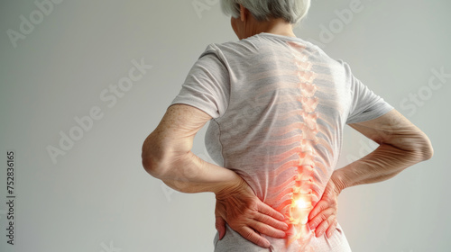 Old woman in white clothes holding her back because she have a painful back suffering from spine pain photo