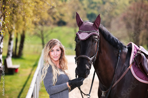 Young woman with long hair and blonde streaks, stands portraits with her horse. © RD-Fotografie