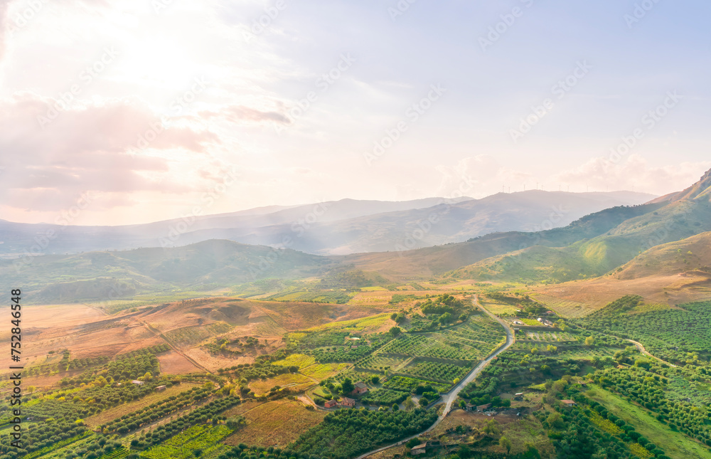 rustic landscape view of rural green valley in mountain hills with farms and gardens