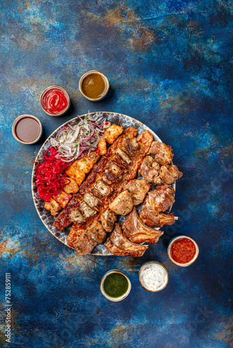 Assorted shashlik or kebab on skewers, grilled on large platter. Traditional dish of Caucasian and Middle Eastern cuisine.