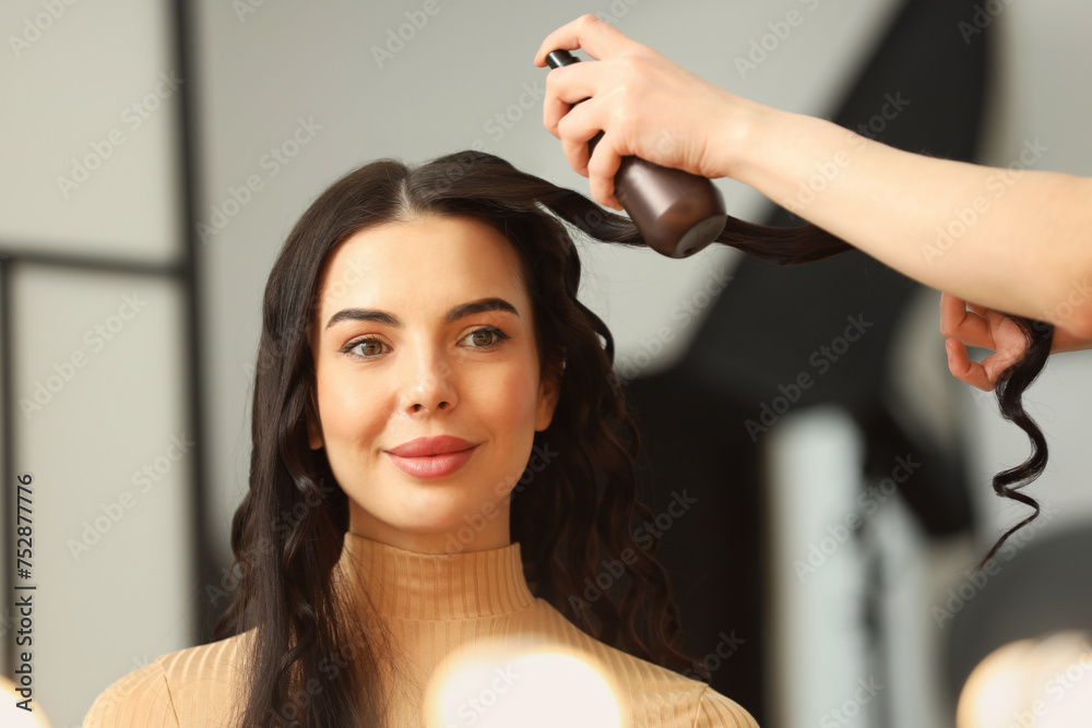 Fototapeta premium Hair styling. Professional hairdresser working with client in salon, closeup