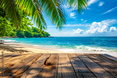 Wooden bench is on beach with clear blue water and palm trees in the background.