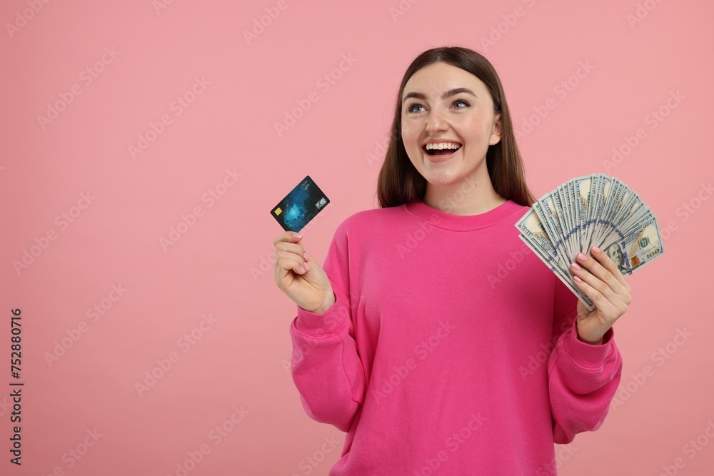 Happy woman with credit card and dollar banknotes on pink background, space for text Happy woman with credit card and dollar banknotes on pink background, space for text