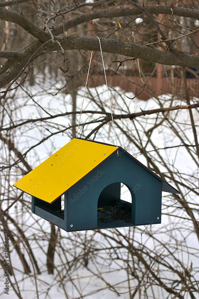 bird feeder in the form of a house with a yellow roof