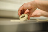 Close-up of baker's hands, bakery and pastry concept. Professional pastry chef making chocolate roll.