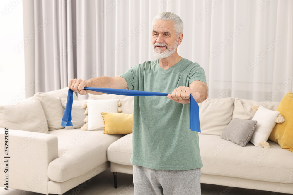 Senior man doing exercise with fitness elastic band at home Senior man doing exercise with fitness elastic band at home