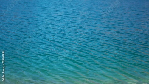 4K Full frame shot of water ripples on the Chandra Taal Lake near Kunzum Pass in Spiti Valley, Himachal Pradesh, India. Water ripples on the blue water of Chandra Tal lake due to the strong winds.  photo