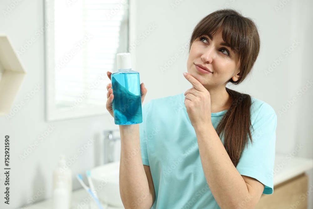 Young woman with mouthwash in bathroom. Oral hygiene Young woman with mouthwash in bathroom. Oral hygiene