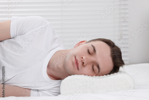 Man sleeping on orthopedic pillow at home © New Africa