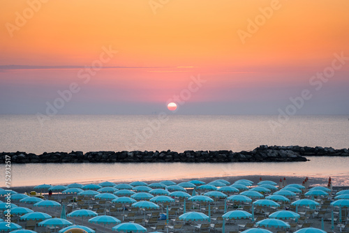 Fototapeta Naklejka Na Ścianę i Meble -  Beautiful sunrise on Rimini beach with umbrellas