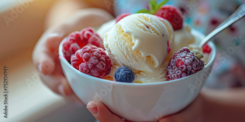 Childrent's hand holding an ice cream cup with 3 fruit flavors, spoon stuck in the ice cream photo