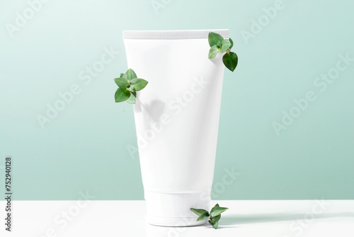 Сosmetic and branches on the table, white container with skin care product
