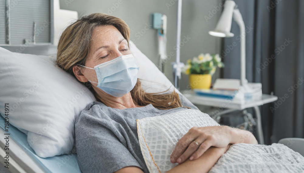 Sick person lying in hospital bed wearin a face mask 