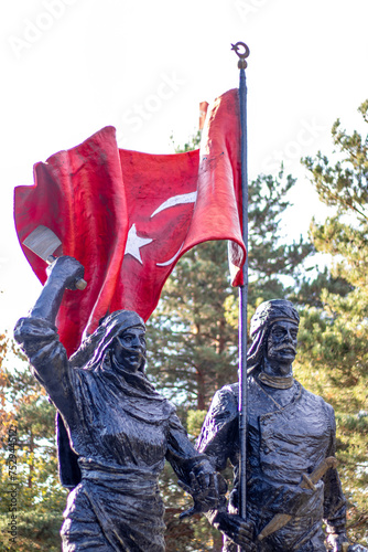 A statue of an Anatolian hero holding the Turkish flag high, alongside a female figure, 12 March 1918 symbolizing the liberation of Erzurum. photo