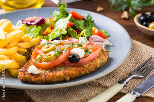 Breaded pork chop in tomatoes. Served with olives and feta cheese.