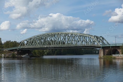 Old metal railway bridge over lake Vanajavesi against sky with clouds in summer, Hämeenlinna, Finland. photo