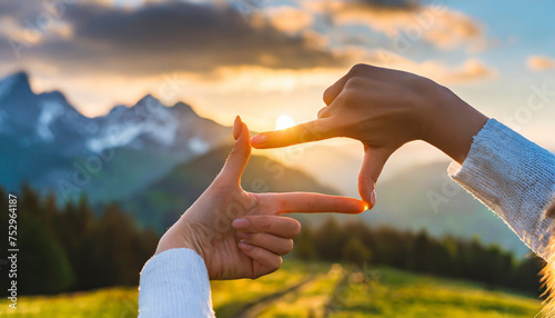 Close up of woman hands making frame gesture with sunrise on moutain, Female capturing the sunrise, Future planning, sunlight outdoor. photo