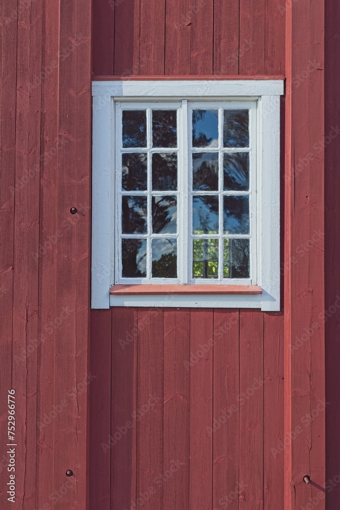 Window with white frame on a old red wooden building. Window with white frame on a old red wooden building.