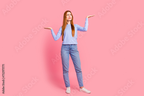Full size photo of minded woman dressed blue shirt make solution choose betwen products look empty space isolated on pink color background photo