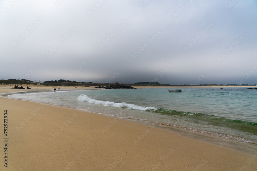 Plage de sable fin et eaux vert émeraude sous un ciel menaçant en Bretagne Plage de sable fin et eaux vert émeraude sous un ciel menaçant en Bretagne