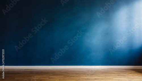 Dark blue wall in an empty room with a wooden floor