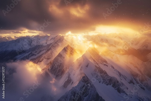 Snow capped mountain peaks with sunlight piercing through clouds