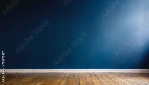 Dark blue wall in an empty room with a wooden floor