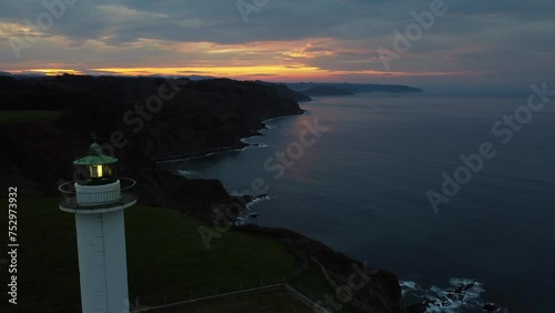 The lighthouse of Lastres at sunset located in the town of Luces, Asturias, Spain. photo