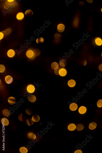 Yellow circles on a black background. Golden bokeh. Gold highlights on black. Yellow mugs in the dark.