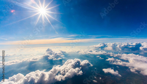 A breathtaking view of a cloud landscape seen from an airplane window, with the sun shining brightly above