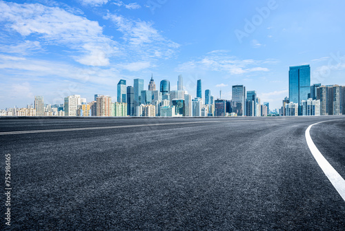 Empty asphalt road and city skyline background © zhao dongfang