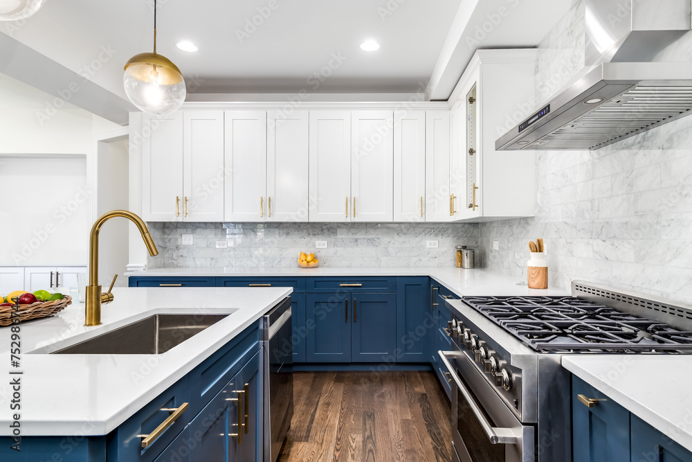 A luxurious white and blue kitchen with gold hardware, stainless steel appliances, and white marbled granite countertops. No brands or labels. - obrazy, fototapety, plakaty 