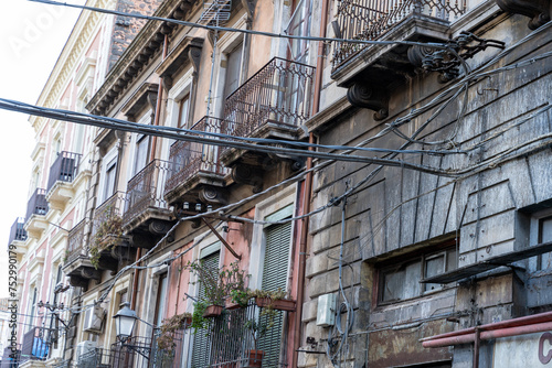 A row of old buildings with a lot of wires hanging from the roof