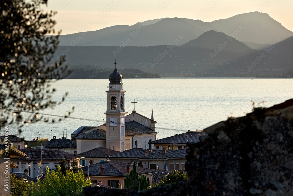 The village of Torri del Benaco with the church of San Pietro e Paolo. In the background Lake Garda. Veneto, Italy.