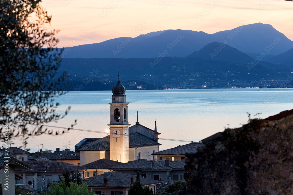 The village of Torri del Benaco with the church of San Pietro e Paolo. In the background Lake Garda. Veneto, Italy.