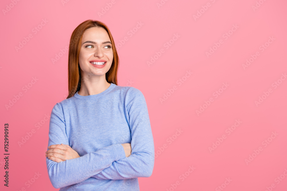 Fototapeta premium Photo of toothy beaming adorable woman dressed blue shirt look at offer empty space arms crossed isolated on pink color background