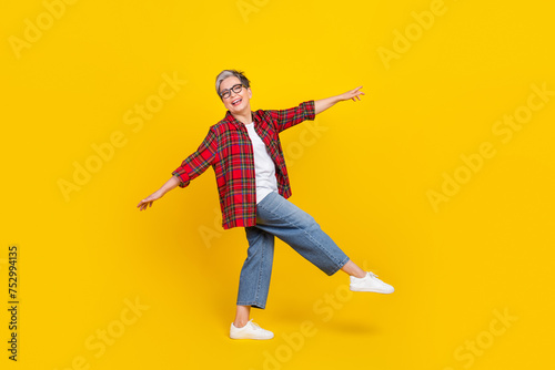 Full size photo of overjoyed crazy aged lady have good mood dancing empty space isolated on yellow color background