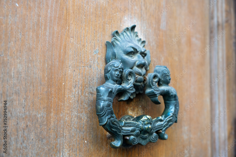 A metal door handle with a face on it A metal door handle with a face on it