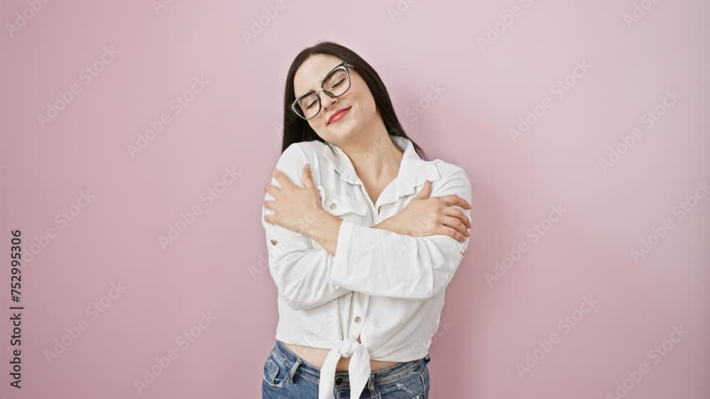 Radiant young hispanic woman joyfully hugging herself over isolated pink background, embodying self love and confidence through her warm smile and positive expression Radiant young hispanic woman joyfully hugging herself over isolated pink background, embodying self love and confidence through her warm smile and positive expression